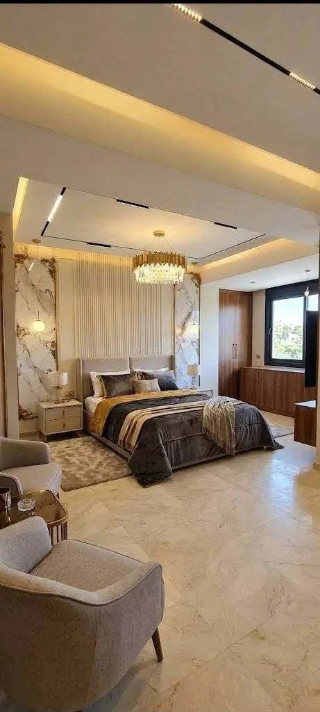 Suite parentale avec plafond éclairé, colonnes en marbre et mur rainuré